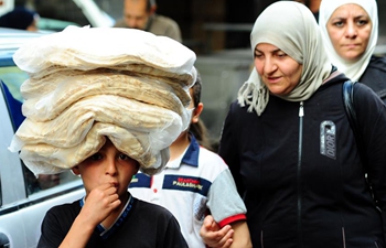 People shop various food items for Muslim holy month of Ramadan in Damascus